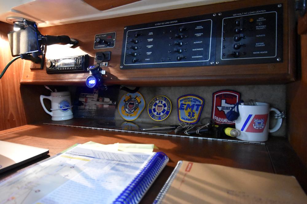 Coast Guard clothing patches line the back of a chart table.