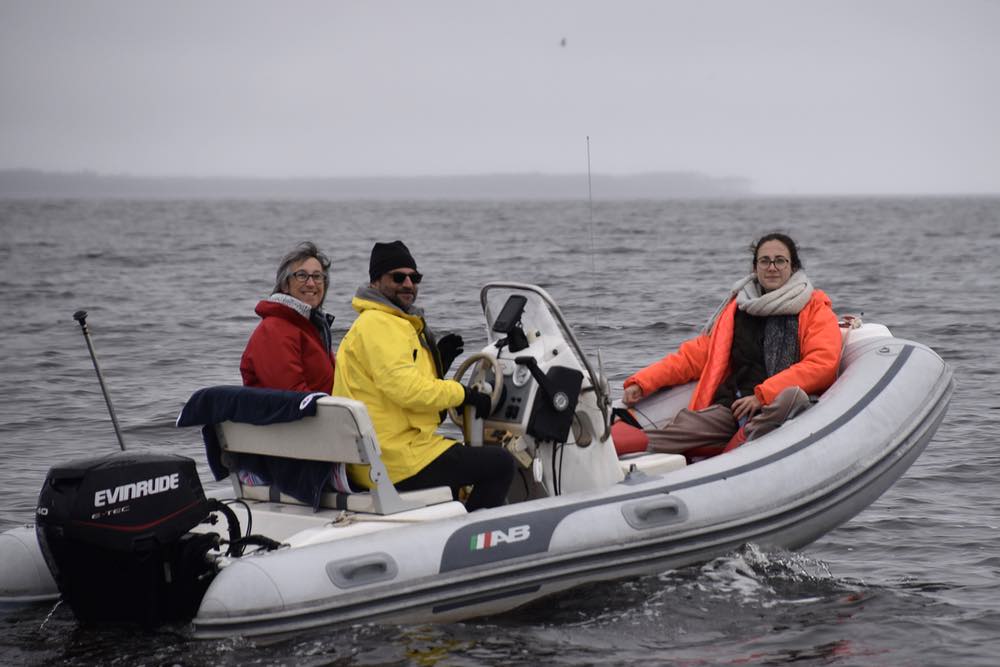 A crew of three ride in a rigid inflatable boat.
